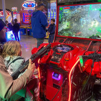 Smiling kids playing claw machines and arcade games at The Fun Lab Blaine, MN.