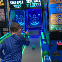Boy playing Skee-Ball arcade game at The Fun Lab
