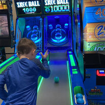 Young guest playing skee-ball in The Fun Lab’s arcade area in Blaine, MN.