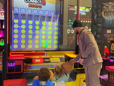 dad and kids playing in the arcade at the fun lab