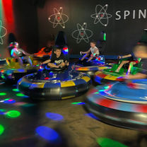 Kids spinning in neon-lit bumper cars at The Fun Lab in Blaine, MN.