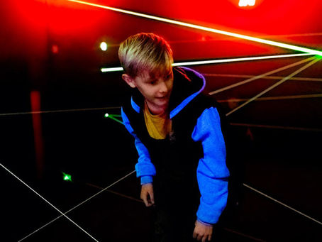 little boy playing in the laser maze at the fun lab